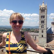 smiling young woman stands in front of cathedral of siena